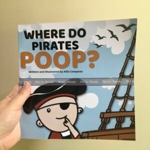Author's hands holding a proof copy of the children's book How Do Pirates Poop?