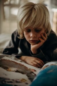 selective focus photography of boy resting his head on his left palm