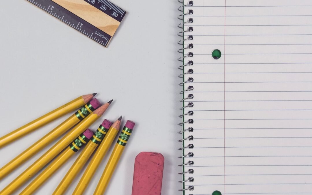 school supplies flat lay with pencils and notebook